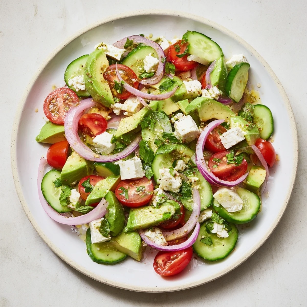 Fresh Cucumber, Tomato, and Avocado Salad with feta, a bright, colorful, Mediterranean dish ready to serve.