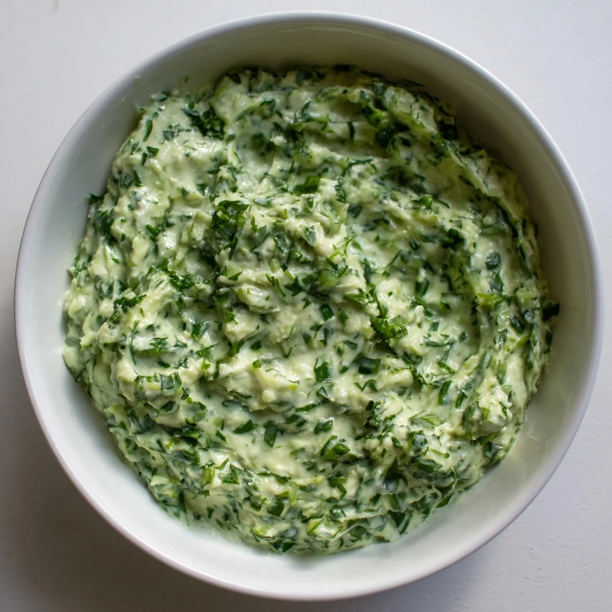 Freshly made Green Goddess Dip, showcasing bright herbs and a smooth, appealing texture.
