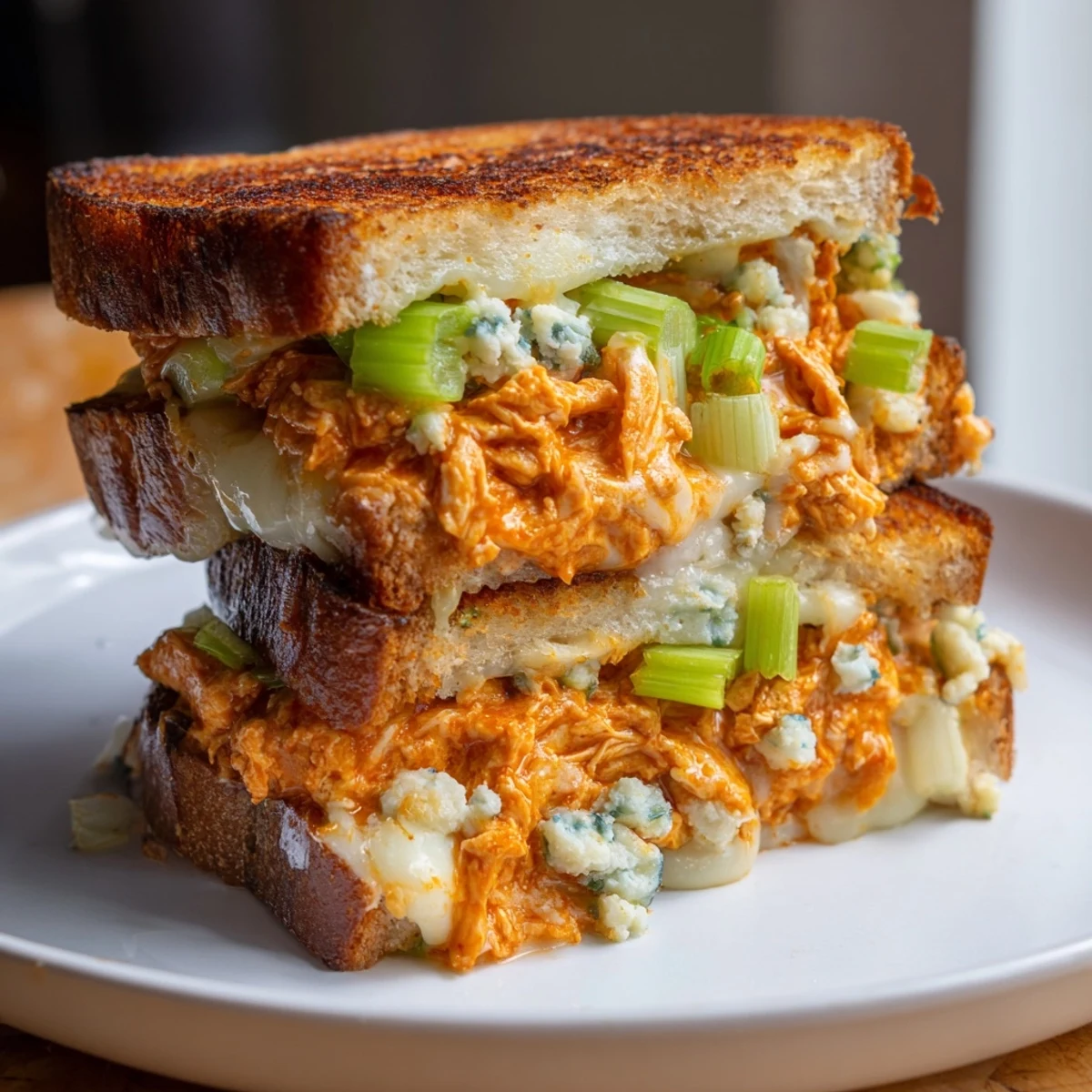Crispy golden-brown sourdough holds creamy, spicy buffalo chicken grilled cheese, ready to eat.