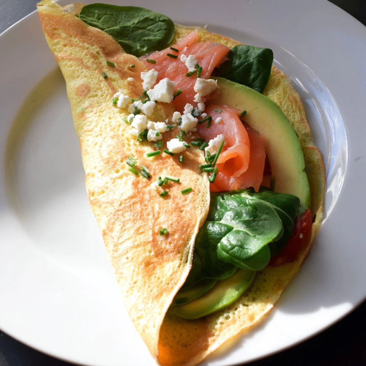 A beautiful close-up of a filled Blender Egg Crepe Wrap with fresh salmon and avocado slices.