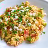 Freshly cooked, colorful menemen scramble with soft eggs and vegetables, a perfect Turkish breakfast idea.