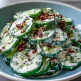 Crisp cucumbers tossed in creamy tangy dressing, sprinkled generously with everything bagel seasoning for savory crunch.