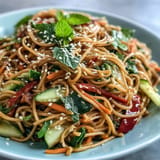 Cold soba noodle salad with inviting sesame ginger dressing, ready to be served.