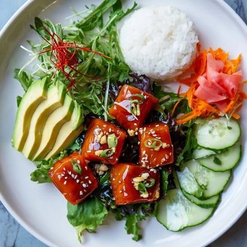 A colorful Poke Bowl Salad with fresh tuna, avocado slices, and sesame seeds drizzled.