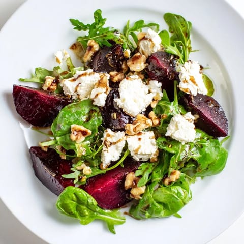 Fresh beet and goat cheese salad arranged on greens, ready for a delicious, refreshing bite.