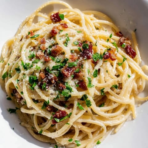 Rich, savory Creamy Garlic Bacon Pasta with fresh parsley and extra Parmesan cheese.