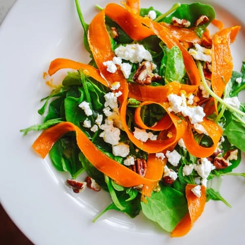 Roasted Carrot Ribbon Salad garnished with crunchy pecans, fresh herbs, and vibrant red onion slices, ready to serve.