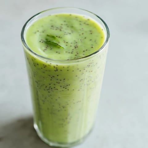 A glass of creamy Detox Smoothie with spinach, banana, and mint, garnished with chia seeds for a nutrient-packed sip.