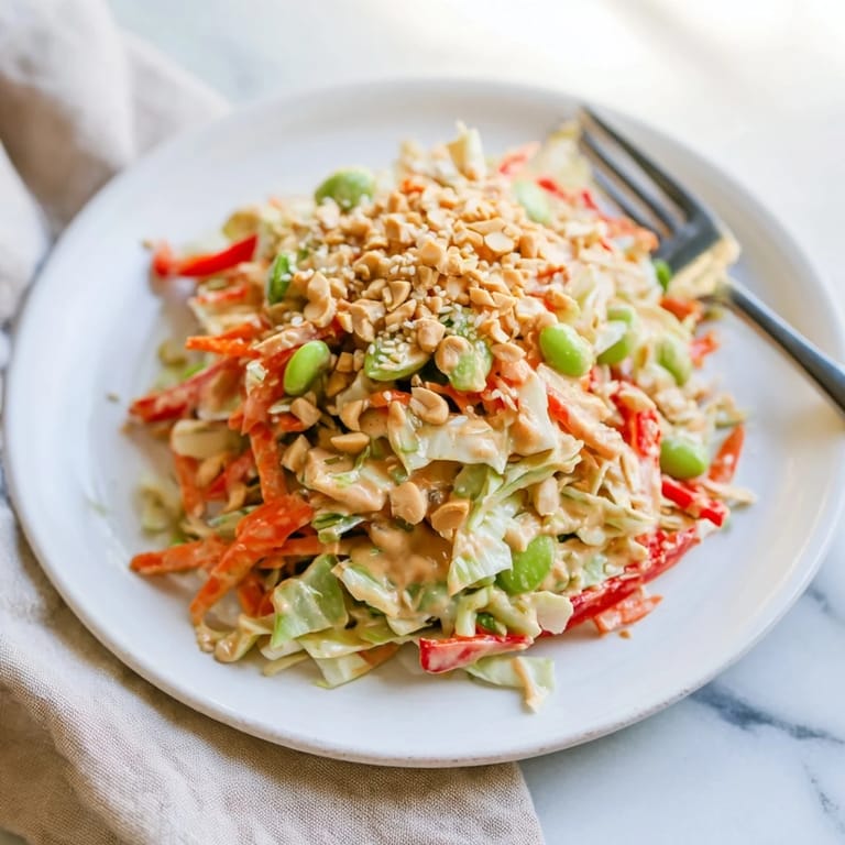Freshly tossed Crunchy Thai Peanut Salad with crisp vegetables and edamame in a creamy peanut sauce, ready to serve.