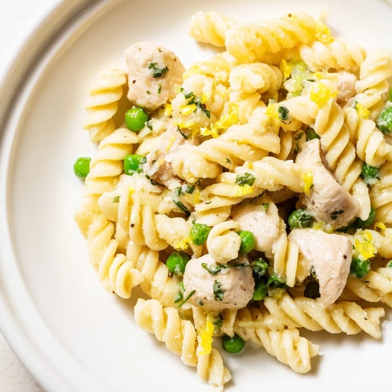 Family-style skillet serving of Garlic Butter Chicken & Pea Pasta, with juicy chicken, vibrant peas, and pasta swirled in a buttery garlic Parmesan sauce.