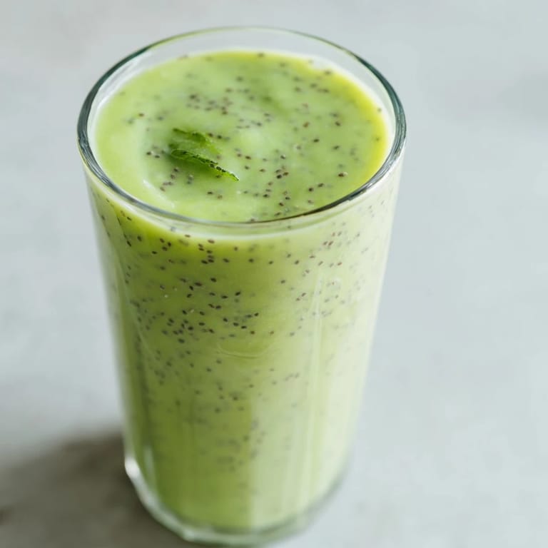 A glass of creamy Detox Smoothie with spinach, banana, and mint, garnished with chia seeds for a nutrient-packed sip.