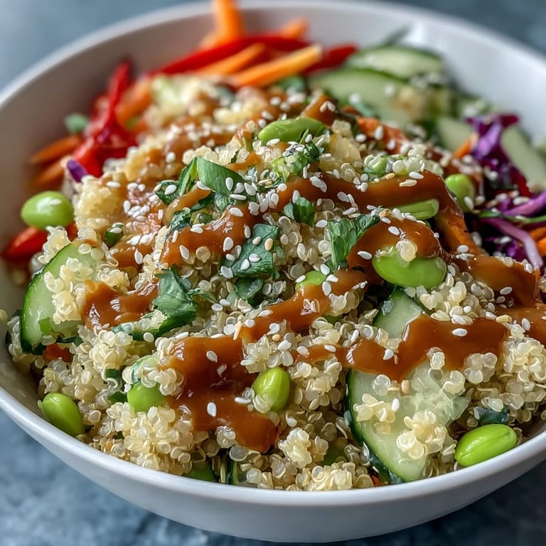 Overhead view of Thai Coconut Quinoa Bowl with fluffy grains, crunchy veggies, and drizzled peanut dressing.